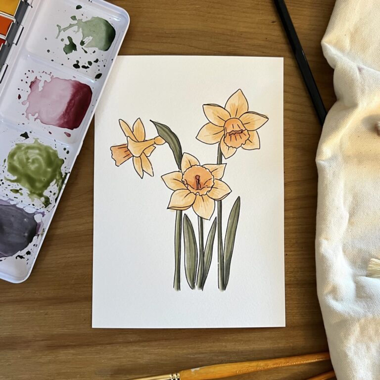Daffodil bunch mini art print A5 by Pippin Prints from above with watercolour paint palette and brushes to the side